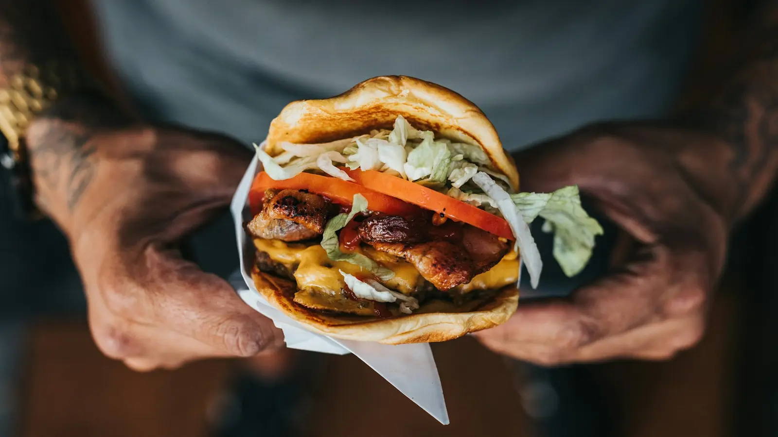 Hands holding a large burger