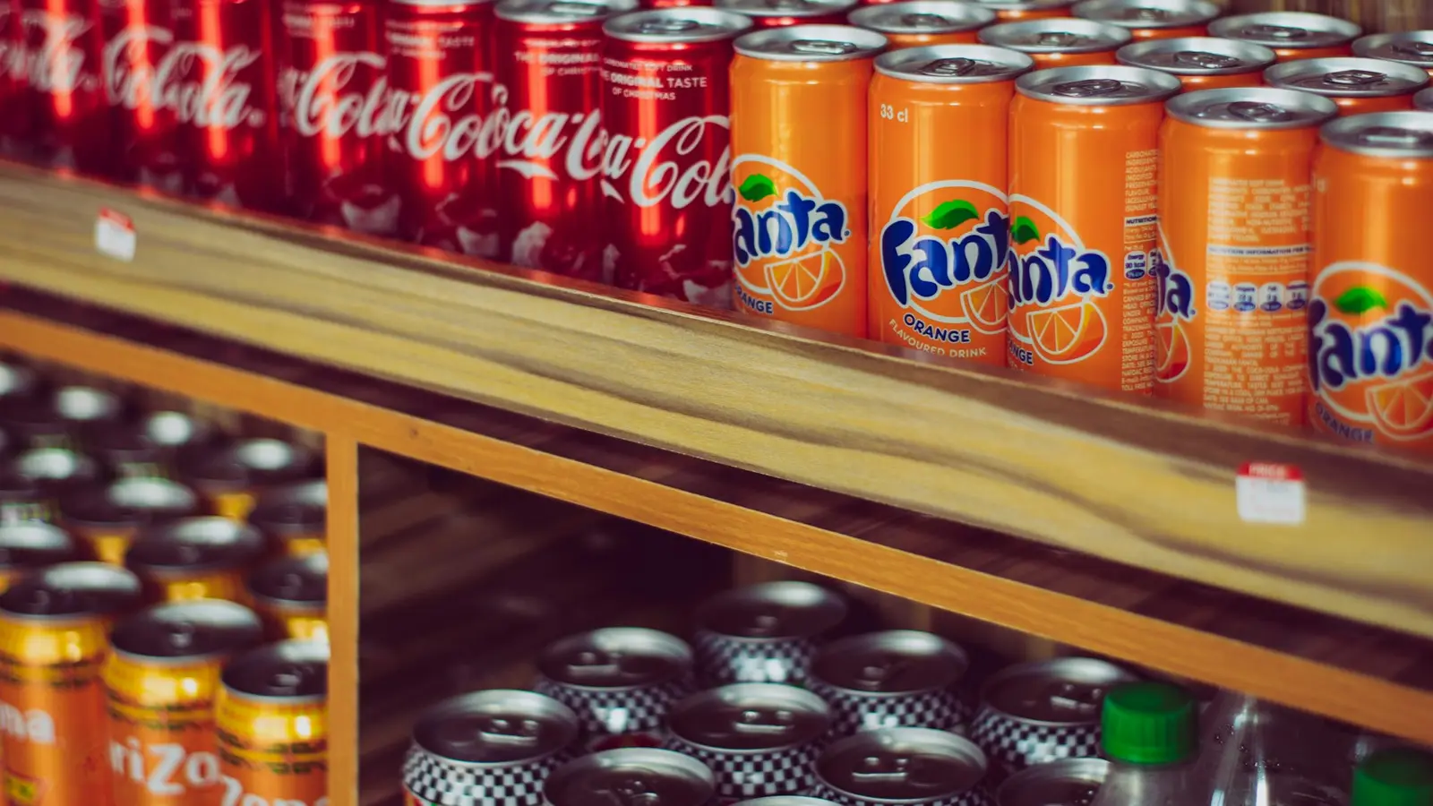 Shelves stacked with cans of soft drinks